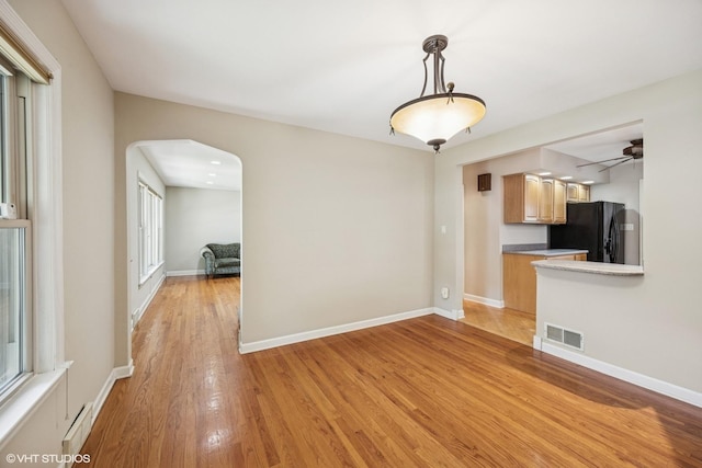 9326 S Millard Ave, Evergreen Park, IL 60805 - unfurnished living room with arched walkways, light wood-type flooring, and ceiling fan
