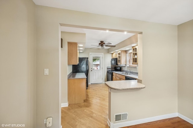 9326 S Millard Ave, Evergreen Park, IL 60805 - kitchen with black appliances, light wood-style flooring, glass insert cabinets, light countertops, and ceiling fan
