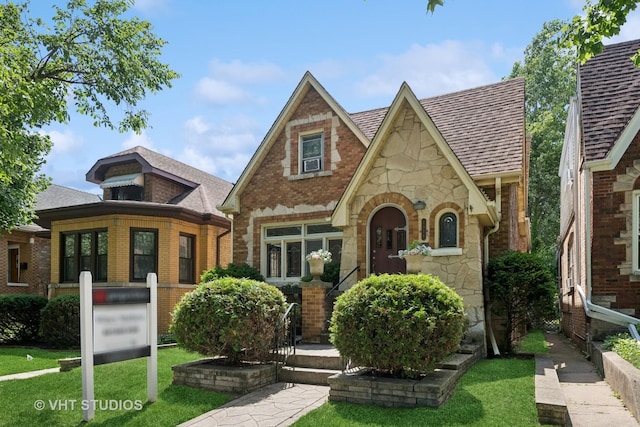 6046 N Monitor Ave, Chicago, IL 60646 - tudor house featuring stone siding, brick siding, and a front lawn