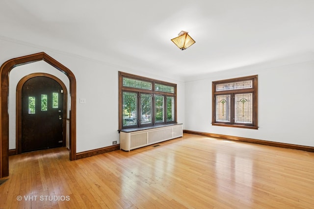 6046 N Monitor Ave, Chicago, IL 60646 - foyer with radiator, light wood-type flooring, healthy amount of natural light, and arched walkways