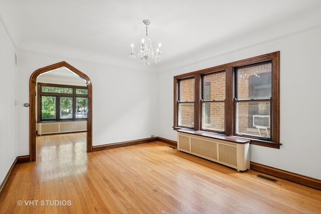 6046 N Monitor Ave, Chicago, IL 60646 - unfurnished room featuring radiator, a chandelier, and light wood finished floors
