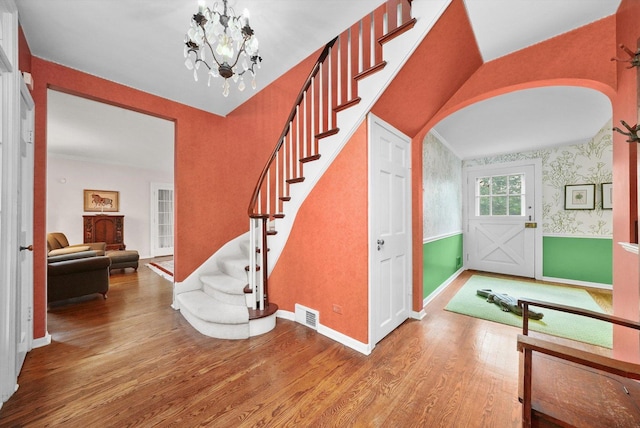 600 Riverwoods Rd, Mettawa, IL 60045 - stairway featuring arched walkways, wood finished floors, a chandelier, and wallpapered walls