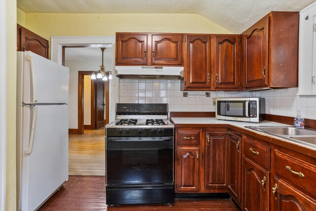 705 Arlington Ct, Champaign, IL 61820 - kitchen featuring freestanding refrigerator, stainless steel microwave, gas range, under cabinet range hood, and dark wood-type flooring