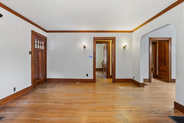 705 Arlington Ct, Champaign, IL 61820 - unfurnished room featuring arched walkways, crown molding, and light wood-style floors