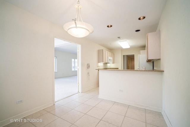 1660 1st St Unit 303, Highland Park, IL 60035 - kitchen with white appliances, light tile patterned floors, decorative light fixtures, and a peninsula