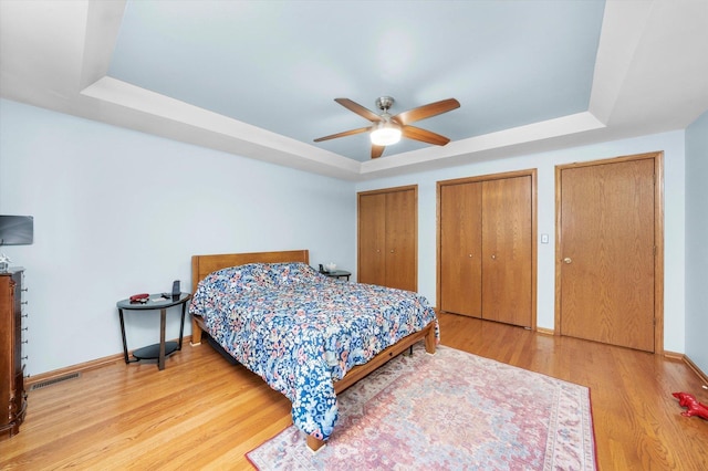 5724 W 82nd Pl, Burbank, IL 60459 - bedroom with a raised ceiling, two closets, wood finished floors, and ceiling fan