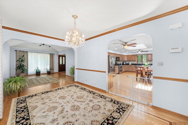 5724 W 82nd Pl, Burbank, IL 60459 - entryway featuring arched walkways, a ceiling fan, light wood-style flooring, a raised ceiling, and ornamental molding