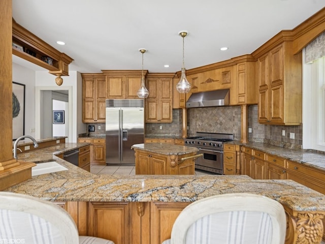 5N113 Burr Rd, Saint Charles, IL 60175 - kitchen featuring premium appliances, wall chimney exhaust hood, a kitchen island, brown cabinetry, and recessed lighting