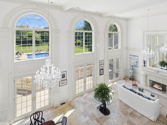 5N113 Burr Rd, Saint Charles, IL 60175 - living room featuring french doors, a chandelier, a decorative wall, beamed ceiling, and stone finish floors
