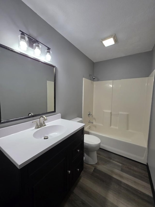 605 Tyler St, Genoa, IL 60135 - bathroom featuring wood finished floors, vanity, washtub / shower combination, and a textured ceiling