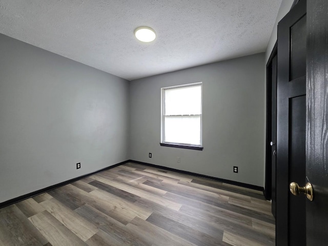 605 Tyler St, Genoa, IL 60135 - empty room with wood finished floors and a textured ceiling