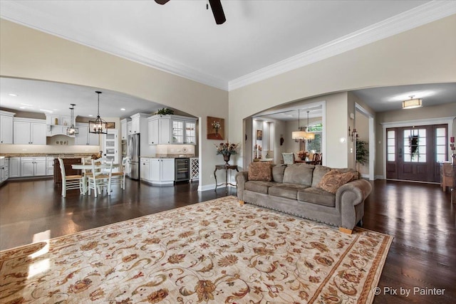 1075 Redbud Ln, Sugar Grove, IL 60554 - living room with beverage cooler, arched walkways, ornamental molding, dark wood-style flooring, and a chandelier