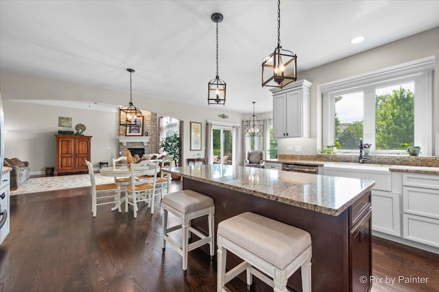 1075 Redbud Ln, Sugar Grove, IL 60554 - kitchen featuring plenty of natural light, a stone fireplace, light stone countertops, a kitchen island, and recessed lighting