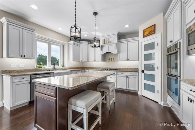 1075 Redbud Ln, Sugar Grove, IL 60554 - kitchen with stainless steel appliances, dark wood-style floors, a kitchen island, a kitchen bar, and hanging light fixtures