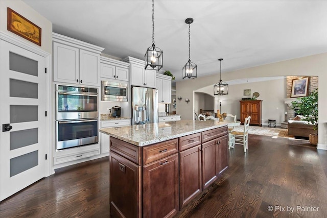 1075 Redbud Ln, Sugar Grove, IL 60554 - kitchen with stainless steel appliances, dark wood-type flooring, open floor plan, hanging light fixtures, and light stone countertops
