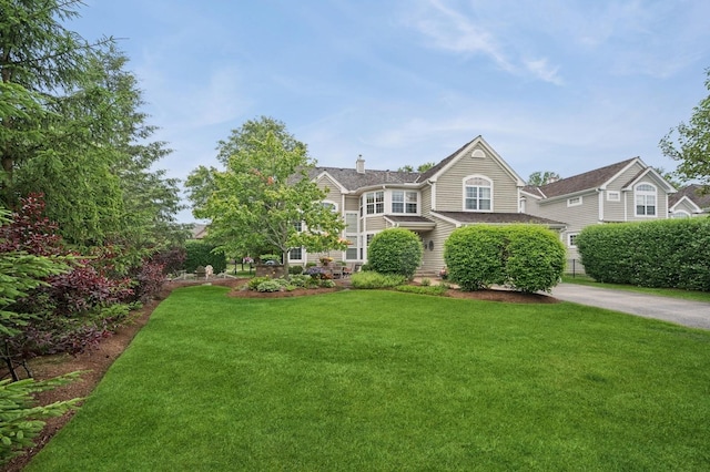 1613 Constitution Dr, Glenview, IL 60026 - view of front facade with a front lawn, a chimney, and driveway