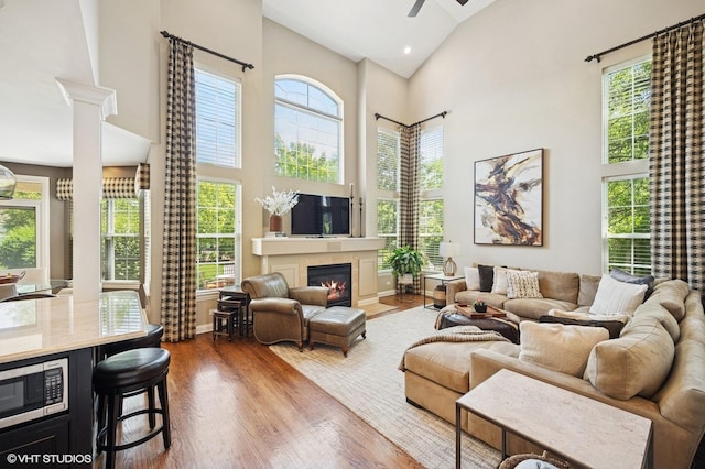 1613 Constitution Dr, Glenview, IL 60026 - living room with high vaulted ceiling, wood finished floors, a tiled fireplace, a ceiling fan, and recessed lighting