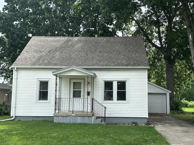1506 17th Ave, Sterling, IL 61081 - cape cod house featuring a shingled roof, an outbuilding, a front yard, and a detached garage