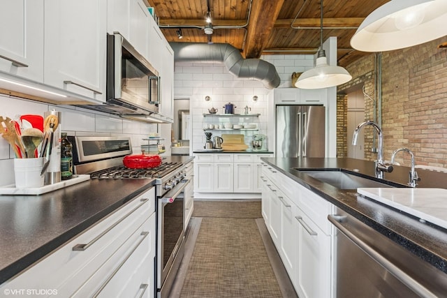 835 N Wood St Unit 301, Chicago, IL 60622 - kitchen featuring a wood ceiling with exposed beams, stainless steel appliances, decorative backsplash, white cabinets, and brick wall