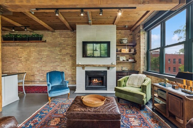 835 N Wood St Unit 301, Chicago, IL 60622 - living area featuring track lighting, brick wall, a wooden ceiling with exposed beams, and a warm lit fireplace