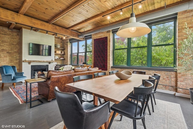 835 N Wood St Unit 301, Chicago, IL 60622 - dining area featuring track lighting, a wooden ceiling with exposed beams, brick wall, dark wood-type flooring, and a warm lit fireplace