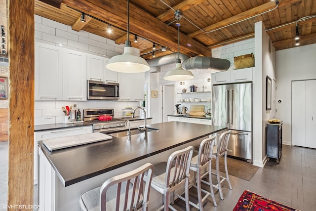 835 N Wood St Unit 301, Chicago, IL 60622 - kitchen featuring stainless steel appliances, dark countertops, a wooden ceiling with exposed beams, track lighting, and open shelves