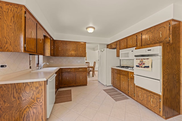 12026 Somerset Rd, Orland Park, IL 60467 - kitchen with white appliances, a warming drawer, light tile patterned floors, tasteful backsplash, and brown cabinets