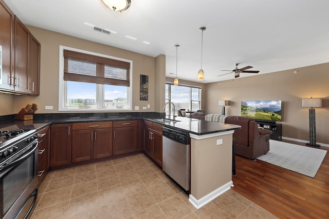 935 Burlington Ave Unit 411, Downers Grove, IL 60515 - kitchen featuring stainless steel appliances, open floor plan, a ceiling fan, a peninsula, and pendant lighting