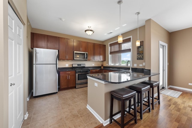 935 Burlington Ave Unit 411, Downers Grove, IL 60515 - kitchen with appliances with stainless steel finishes, a peninsula, a breakfast bar area, pendant lighting, and dark stone counters