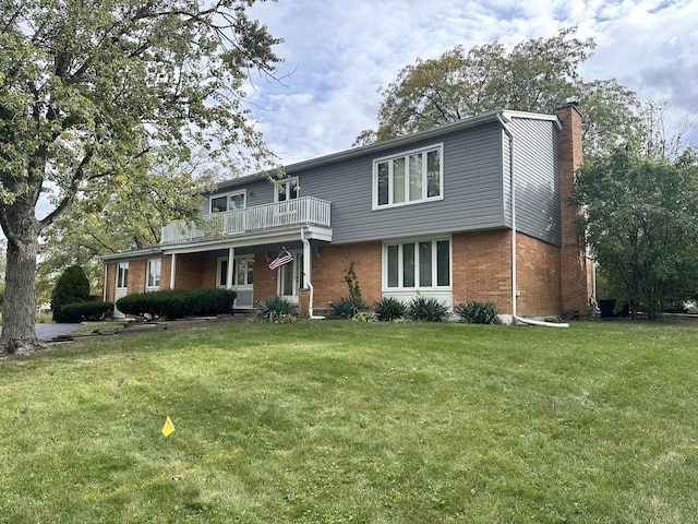 56 Graymoor Ln, Olympia Fields, IL 60461 - view of front facade with a chimney, brick siding, a front yard, and a balcony