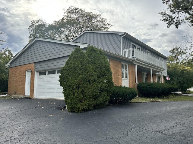 56 Graymoor Ln, Olympia Fields, IL 60461 - view of side of property featuring brick siding, a balcony, a garage, and driveway