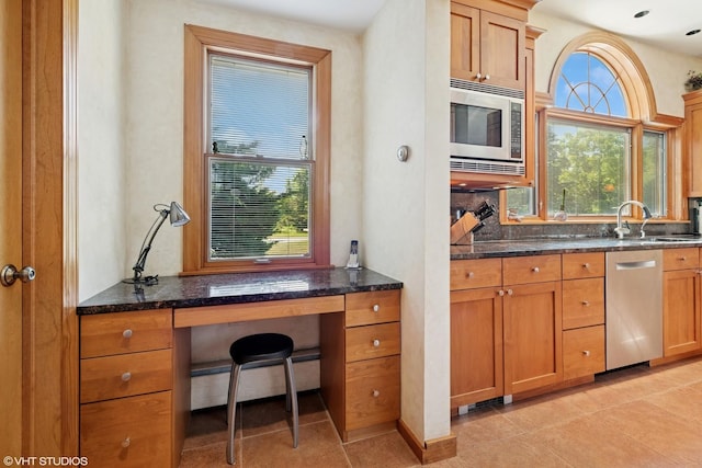 130 Old Dundee Rd, Barrington Hills, IL 60010 - kitchen featuring stainless steel appliances, dark stone counters, a baseboard heating unit, light tile patterned floors, and brown cabinets