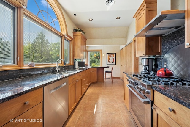 130 Old Dundee Rd, Barrington Hills, IL 60010 - kitchen featuring appliances with stainless steel finishes, wall chimney range hood, tasteful backsplash, light tile patterned floors, and dark stone counters