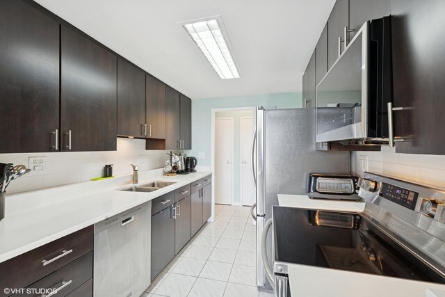 5050 S E End Ave Unit 9C, Chicago, IL 60615 - kitchen featuring appliances with stainless steel finishes, light countertops, light tile patterned floors, decorative backsplash, and dark brown cabinetry