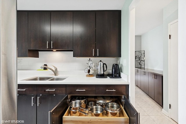 5050 S E End Ave Unit 9C, Chicago, IL 60615 - kitchen featuring light countertops, light tile patterned floors, decorative backsplash, and dark brown cabinets