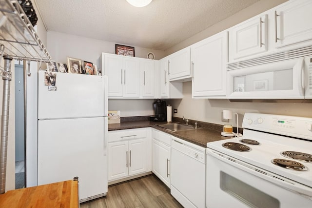 10 E Ontario St Unit 1304, Chicago, IL 60611 - kitchen featuring white appliances, dark countertops, white cabinetry, light wood finished floors, and a textured ceiling