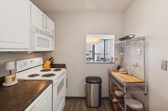 10 E Ontario St Unit 1304, Chicago, IL 60611 - kitchen with white appliances, dark wood-style flooring, dark countertops, white cabinets, and a chandelier