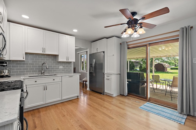 8941 Timothy Ct, Orland Park, IL 60462 - kitchen featuring stainless steel refrigerator with ice dispenser, light countertops, light wood-style floors, gas range, and white cabinetry