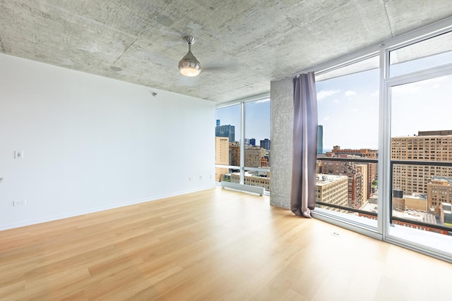 611 S Wells St Unit 2301, Chicago, IL 60607 - empty room with a wall of windows, a skyline view, healthy amount of natural light, wood finished floors, and ceiling fan