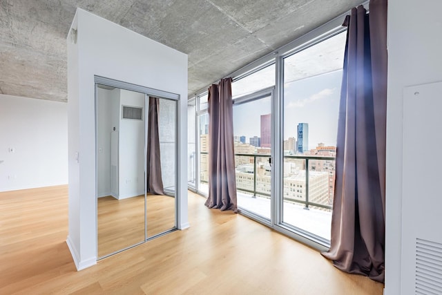 611 S Wells St Unit 2301, Chicago, IL 60607 - unfurnished bedroom featuring wood finished floors, a view of skyline, expansive windows, access to outside, and a closet