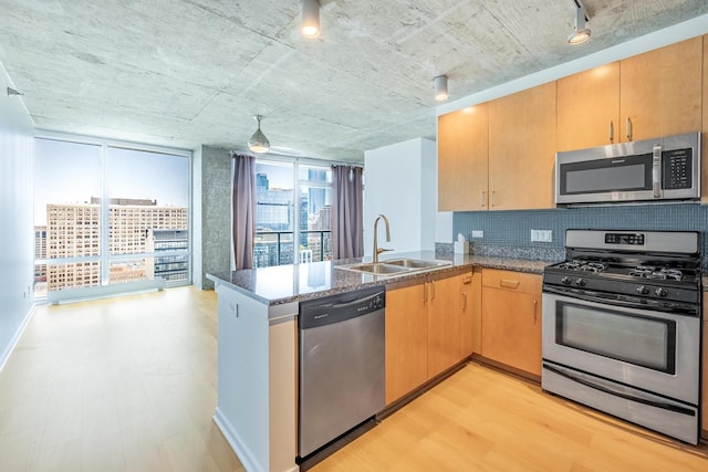 611 S Wells St Unit 2301, Chicago, IL 60607 - kitchen featuring stainless steel appliances, a peninsula, backsplash, dark stone countertops, and light flooring