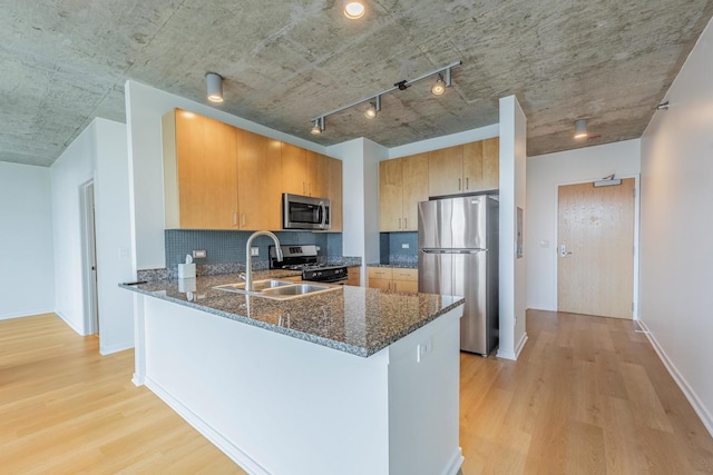 611 S Wells St Unit 2301, Chicago, IL 60607 - kitchen with appliances with stainless steel finishes, dark stone counters, light wood-style floors, a peninsula, and tasteful backsplash