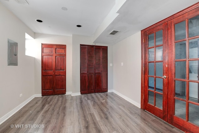 212 E 44th St Unit 2, Chicago, IL 60653 - unfurnished bedroom featuring electric panel, wood finished floors, and french doors