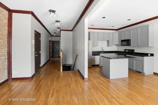 212 E 44th St Unit 2, Chicago, IL 60653 - kitchen featuring black appliances, gray cabinetry, light wood-type flooring, ornamental molding, and dark countertops