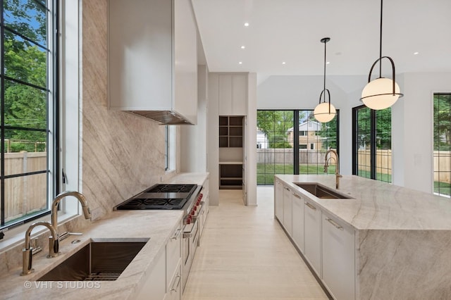 759 Strawberry Hill Dr, Glencoe, IL 60022 - kitchen with white cabinetry, light stone countertops, decorative backsplash, healthy amount of natural light, and recessed lighting