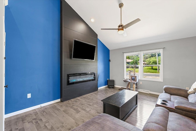501 N Center St, Colfax, IL 61728 - living room featuring a large fireplace, light wood-style flooring, a ceiling fan, and vaulted ceiling