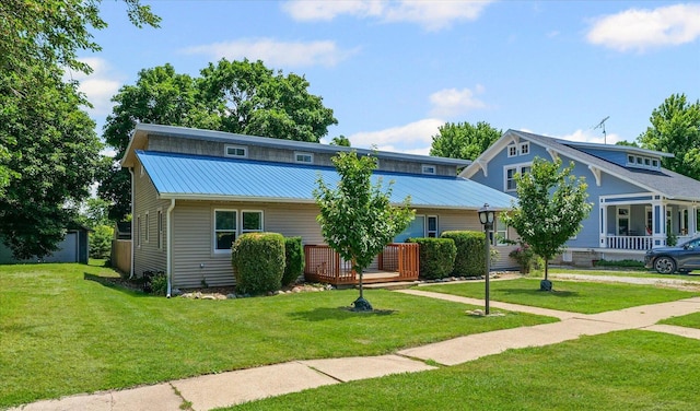 501 N Center St, Colfax, IL 61728 - view of front of property featuring a front lawn, a metal roof, and a deck