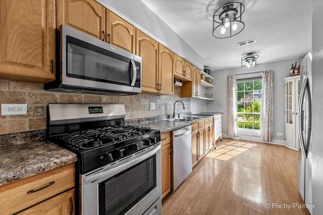 521 Nebraska Cir, Carol Stream, IL 60188 - kitchen featuring appliances with stainless steel finishes, light wood-style flooring, tasteful backsplash, and dark countertops