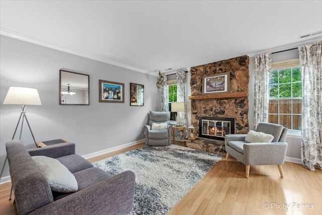 521 Nebraska Cir, Carol Stream, IL 60188 - living area with plenty of natural light, wood finished floors, a stone fireplace, and ornamental molding