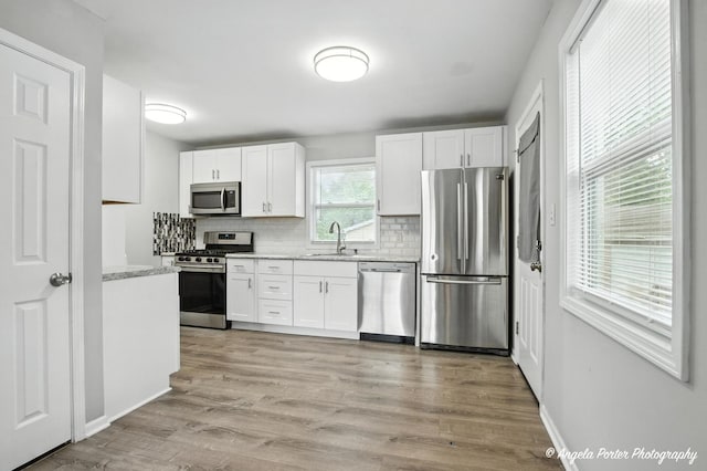 4420 Clearview Dr, Mchenry, IL 60050 - kitchen featuring appliances with stainless steel finishes, tasteful backsplash, white cabinetry, and light wood-style floors